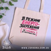 Шопер в режимі енергозбереження, бежевий, на столі, текст на передній частині, бренд.