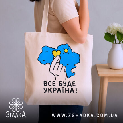 Шопер все буде Україна, бежевий, на руці, з квітами на фоні, бренд.