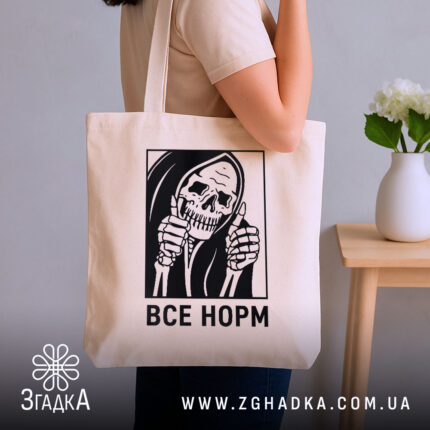 Шопер все норм скелет, бежевий, на плечі у моделі, фон нейтральний, бренд.