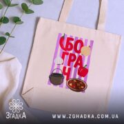 Шопер з принтом бограч, бежевий, на столі, зелений фон, бренд Згадка.