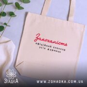 Шопер закоханість офіційний спонсор, бежевий, зверху, фон з рослинами, текст на передній.