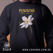 Світшот розквітай навіть після бурі, чорний, близький план, квітка на грудях, бренд.