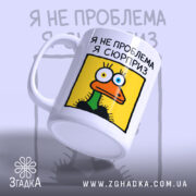Чашка я не проблема я сюрприз, з боку ручки, матовий край, бренд.