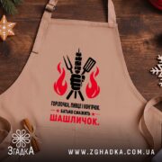 Фартух батько смажить шашличок, бежевий, на дерев'яному фоні, бренд Згадка.