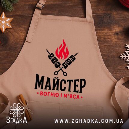 Фартух майстер вогню і м`яса, бежевий фон, на дерев'яному столі, бренд Згадка.