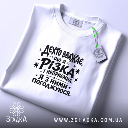 Футболка різка і неприємна, біла, на столі, етикетка видна, бренд Згадка.