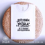 Футболка різка і неприємна, біла, складена на кошику, принт чорний, бренд Згадка.