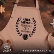 Фартух наша бабуся - бежевий фартух на дерев'яному фоні, бренд Згадка.