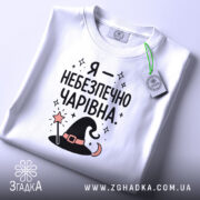 Футболка я небезпечно чарівна, складена, біла, з етикеткою, принт з шапкою, бренд.