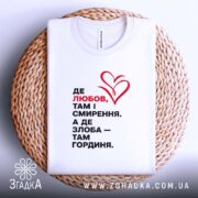 Футболка любов і гординя, біла, на столі, принт червоний і чорний, текстура.