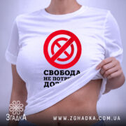 Футболка свобода не потребує дозволу, біла, на моделі, з піднятим краєм, бренд.