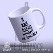 Чашка я вже давно нічому не дивуюся, нахилена, глянцева, ручка праворуч, фон.