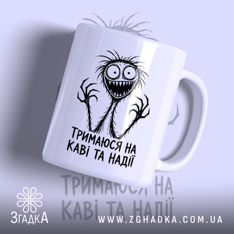Чашка тримаюся на каві та надії, біла з принтом, бренд Згадка.