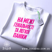 Футболка на межі геніальності та паніки, складена, з етикеткою, бренд Згадка.