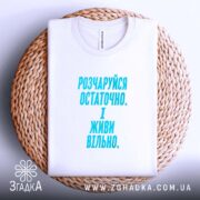 Футболка розчаруйся остаточно і живи вільно, складена на кошику, біла, з принтом,.