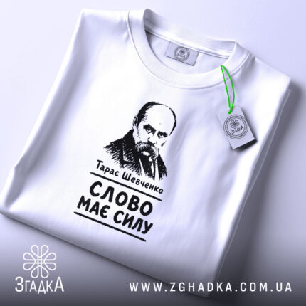 Футболка Тарас Шевченко слово має силу, біла, на столі, з етикеткою, бренд.