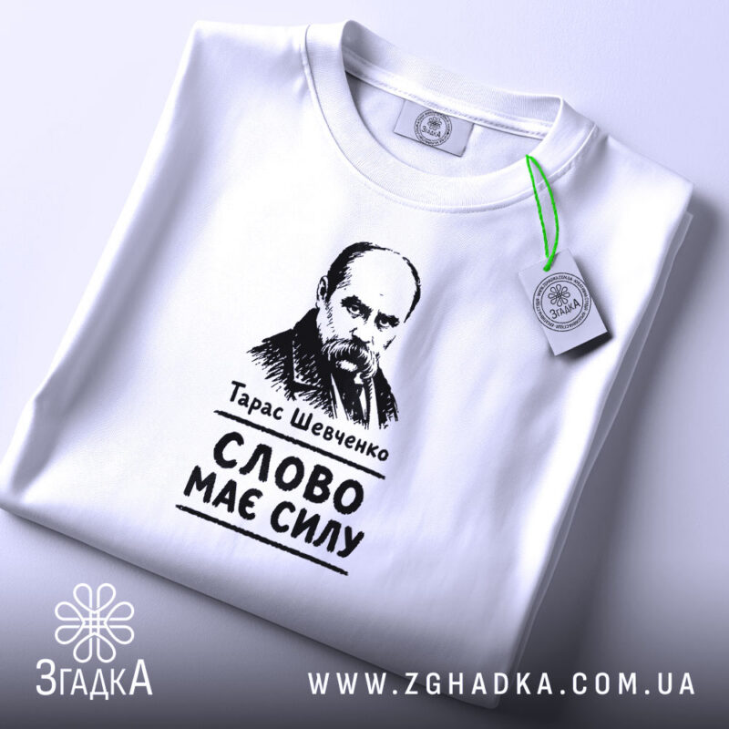 Футболка Тарас Шевченко слово має силу, біла, на столі, з етикеткою, бренд.