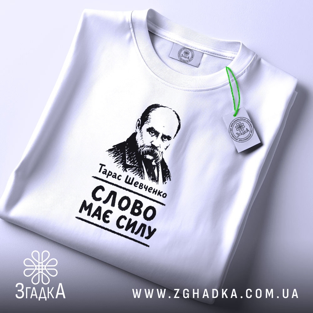 Футболка Тарас Шевченко слово має силу, біла, на столі, з етикеткою, бренд.