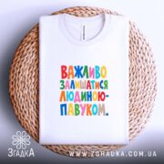 Футболка важливо залишатися людиною павуком, лежить на плетеній основі, бренд Згадка.