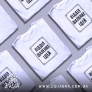 Футболка відділ шалених ідей, біла, на столі, з кількома футболками, бренд Згадка.
