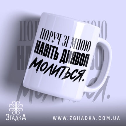 Чашка поруч зі мною навіть диявол молиться, біла з чорним написом.