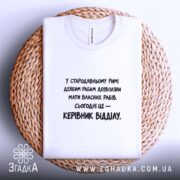 Футболка: біла, на кошику, принт чорний, текстура тканини видна.
