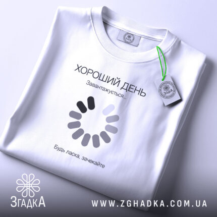 Футболка: складена, біла, з етикеткою.