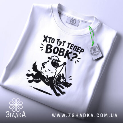 Футболка: складена, біла, з етикеткою, принт на грудях.