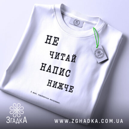 Футболка: складена, біла з принтом.