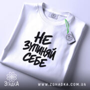 Футболка: складена, біла, з етикеткою.