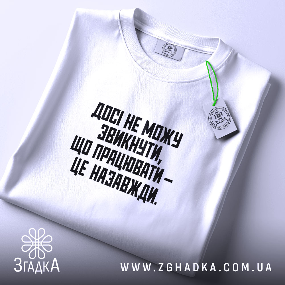 Футболка: біла футболка на столі з етикеткою.
