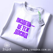 Футболка: складена, біла, принт фіолетовий.
