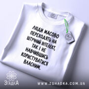 Футболка: складена, біла, з етикеткою, принт чорний.