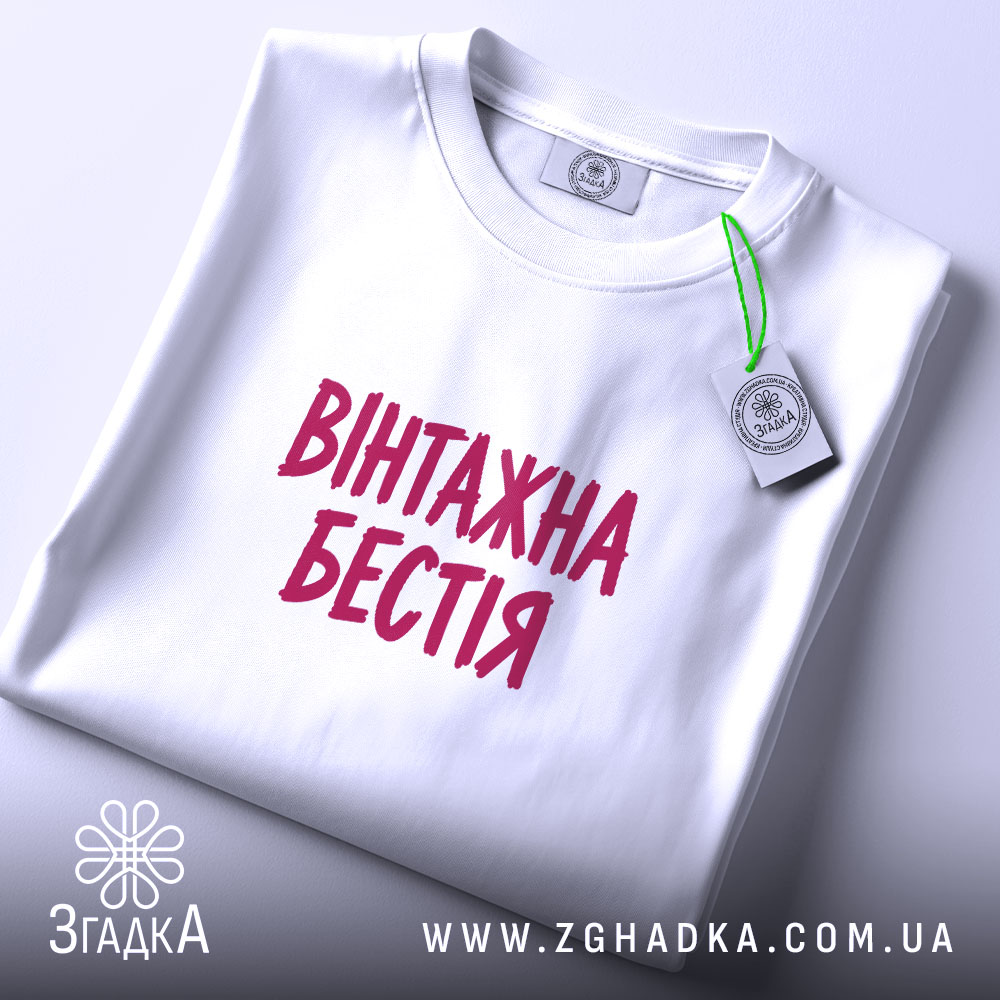 Футболка: складена, біла, з етикеткою.