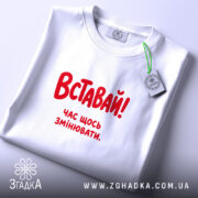Футболка: складена, біла, з етикеткою.