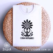 Складена футболка з написом «Сила всередині» на плетеній поверхні.